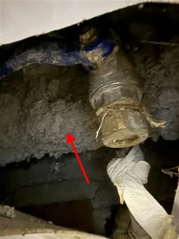 Flocage dégradé sur une canalisation en cave d'immeuble